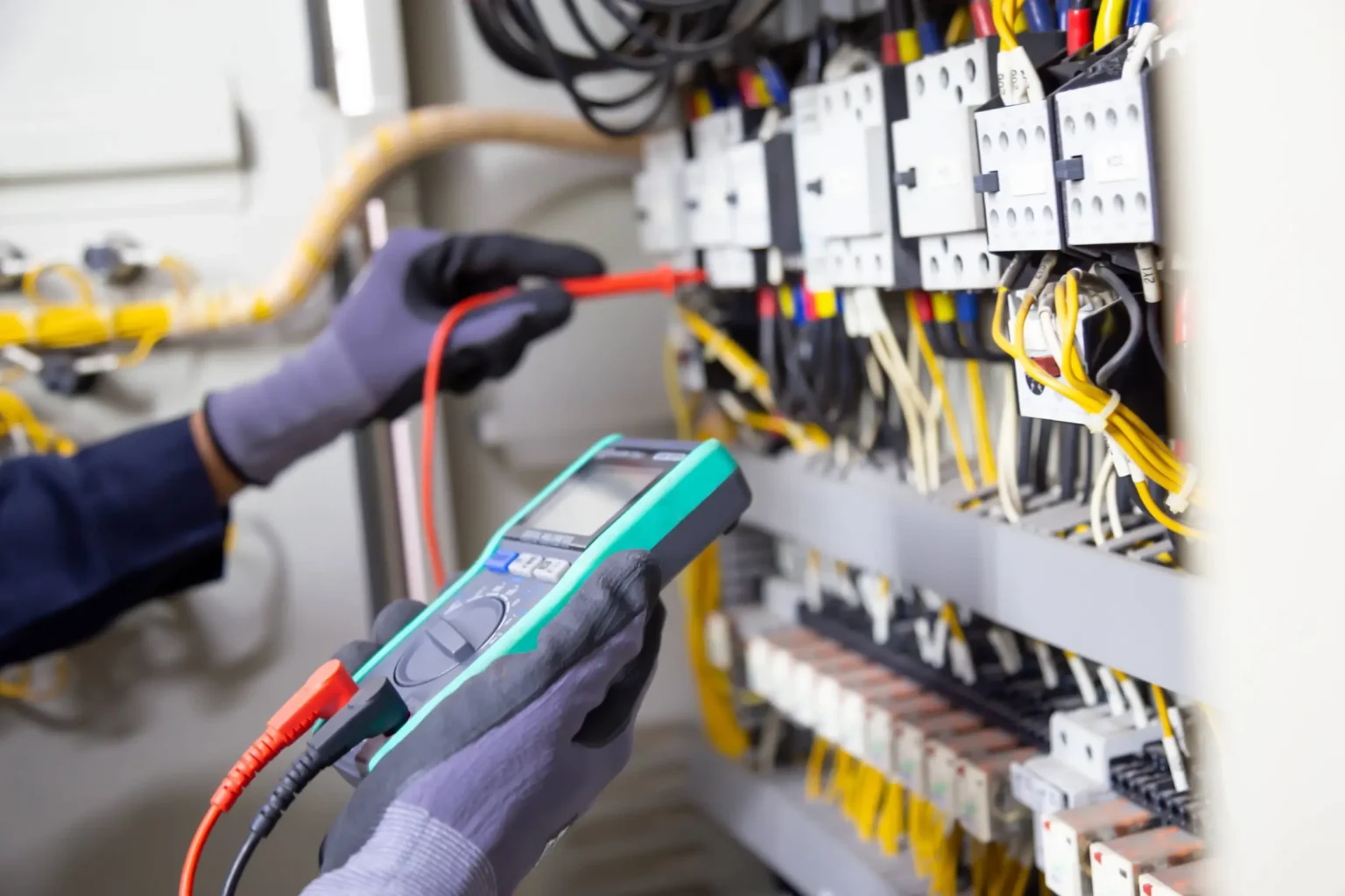 electrician using digital multimeter - L & W Electrical Ltd Electrician using a digital multimeter to inspect electrical circuits – reliable electrical testing and safety checks by L&W Electrical Ltd in Swansea.